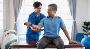 Gambar fisioterapis Fisiohome sedang menangani pasien pria dengan penuh perhatian - Fisiohome